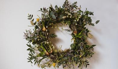 Image shows a spring wreath, full of seasonal foliage